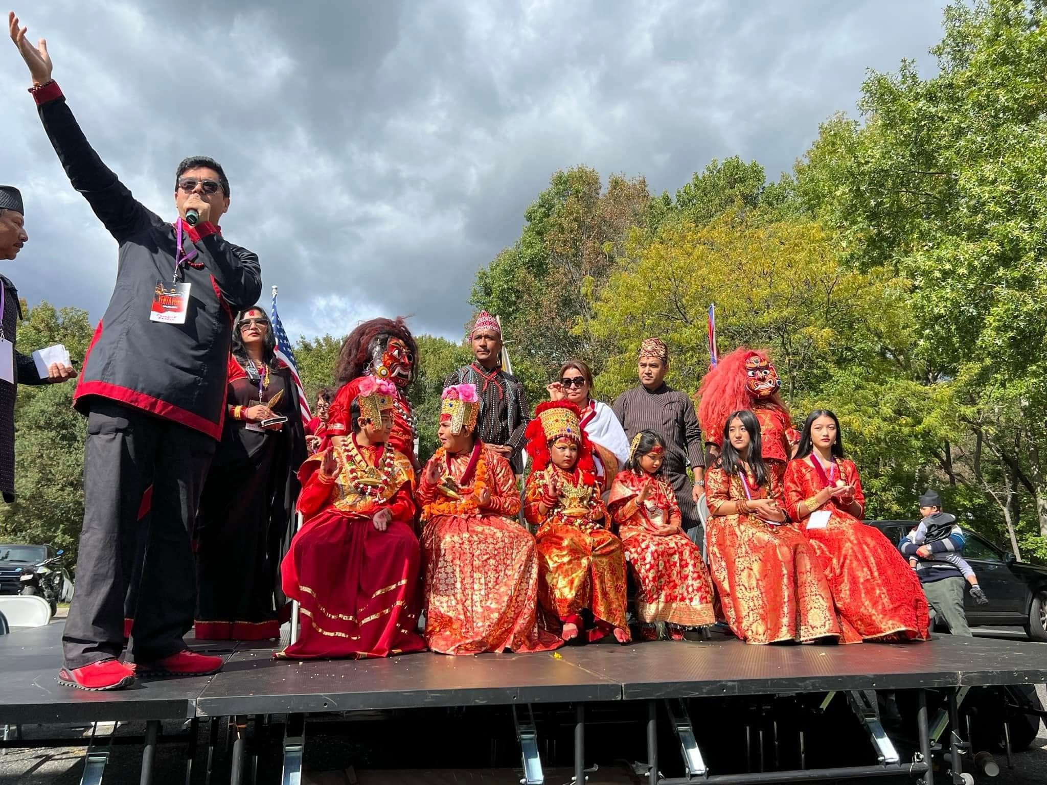 Emcee on stage with community dignitaries and children in traditional costume